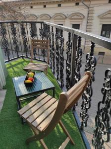 a balcony with a chair and a bench on the grass at City Art Inn in Szeged