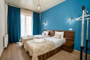 two beds in a room with blue walls at Eltisy Guest House in Kazbegi