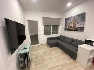 a living room with a couch and a tv at Apartamentos BEACHYDAYS Montalvo in Torremolinos