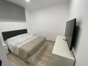 a white bedroom with a bed and a white dresser at Apartamentos BEACHYDAYS Montalvo in Torremolinos