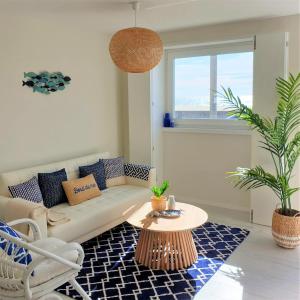 un soggiorno con divano e tavolo di The Shore @ Atlantic Beach - Waterfront Beach House, Tiny Pool, Terrasse a Espinho