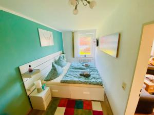 a small bedroom with a bed and a window at Strandnixe Cuxhaven in Cuxhaven