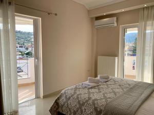 a bedroom with a bed and a large window at Rosa’s Apartments in Lefkada Town
