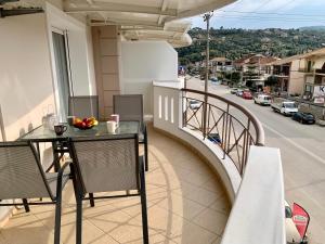 a balcony with a table and a view of a street at Rosa’s Apartments in Lefkada Town