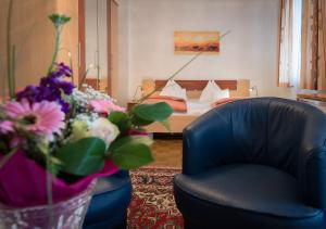 a room with a chair and a bed with flowers at Pension Dr. Geissler in Vienna