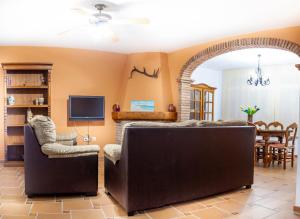 - un salon avec un canapé et une télévision dans l'établissement Hacienda El Romeral, à Zahora