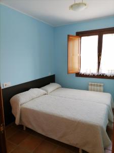 Ce lit se trouve dans une chambre dotée d'un mur bleu. dans l'établissement capricho 2 asturias COLOMBRES, à Ribadedeva