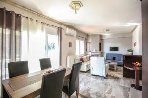 ein Wohnzimmer mit einem Tisch, Stühlen und einem Sofa in der Unterkunft Meteora Fantasia Luxury Residence in Kalambaka