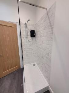 a bathroom with a shower with a stone wall at Courtybella Mews in Newport