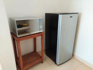 a black refrigerator and a microwave on a table at Sunset House Zihuatanejo in Zihuatanejo