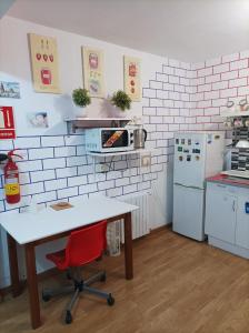 cocina con mesa y silla roja en ArArAt Hostel, en Santiago de Compostela