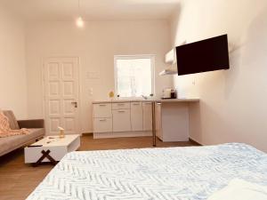a white room with a bed and a kitchen at Louvros Luxury Suites in Dassia