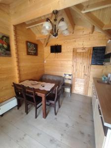 a dining room with a table and chairs in a cabin at Siedlisko Zacisze in Policzna +6 photos