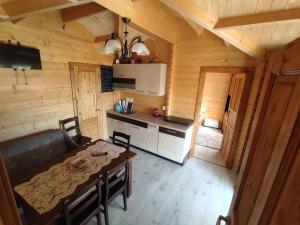 a kitchen and dining room in a log cabin at Siedlisko Zacisze in Policzna