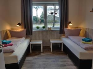 2 camas en una habitación con ventana en Ferienhaus in Lathen - Haus Hummel und Haus Schmetterling, en Lathen