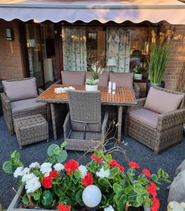 a patio with a table and chairs and flowers at bel-appartement-avec-terrasse in Bad Schwartau