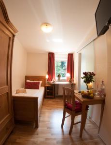 a bedroom with a bed and a desk and a table with a chair at Ringhotel Lutherhotel Eisenacher Hof in Eisenach