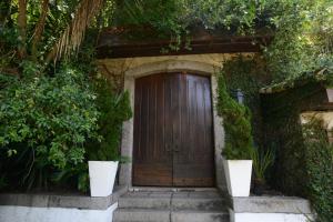 
a doorway leading to a garden filled with plants at Le Chateaux Joá Boutique Hotel in Rio de Janeiro
