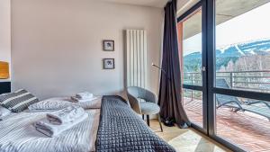 a bedroom with two beds and a balcony at Apartament Triventi 99 z Widokiem - 5D Apartamenty in Karpacz