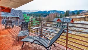a balcony with two chairs and a view of the mountains at Apartament Triventi 99 z Widokiem - 5D Apartamenty in Karpacz