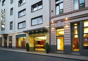 ein Gebäude mit großen Fenstern auf einer Stadtstraße in der Unterkunft Hotel Flandrischer Hof in Köln