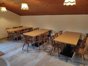 a dining room with wooden tables and chairs at Plonerhof - Ferienhaus Maria in Rodengo