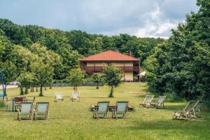 a group of chairs sitting in the grass in front of a house at Farma Ovčí Terasy in Němčičky