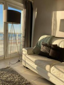 a living room with a couch in front of a window at Knappe studio met subliem zeezicht! in Ostend