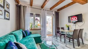 - un salon avec un canapé vert et une table en verre dans l'établissement Karpaczowy Klimat przy Deptaku - 5D Apartamenty, à Karpacz