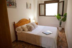 een slaapkamer met een bed met een boek erop bij Casa Ramos in Navarrés