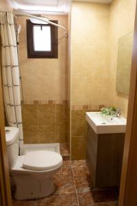 a bathroom with a toilet and a sink and a window at Casa Ramos in Navarrés