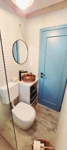 a bathroom with a toilet and a blue door at Seaside cottage 'Little white port' in Lučica +40 photos