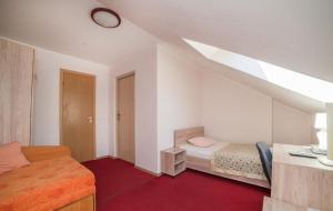 Un pequeño dormitorio con una cama y una escalera en Idilė Bed & Breakfast - Visaginas, en Visaginas