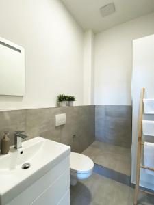 a bathroom with a white sink and a toilet at Best Boarding House in Hanau am Main