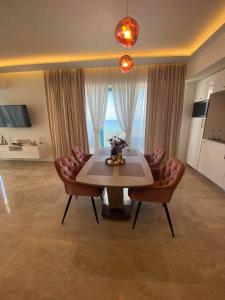 a dining room with a table and two chairs at APARTAMENT De LUX ZEV MEDITERANEO in Mamaia Sat/Năvodari