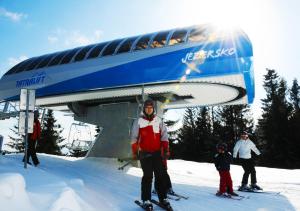 a group of people on a ski lift in the snow at Privát Bayer in Ždiar