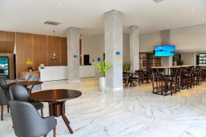 a lobby with tables and chairs and a bar at Days Inn By Wyndham Cascavel in Cascavel
