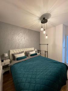 a bedroom with a bed with a green comforter at Skyline apartment in Bijeljina