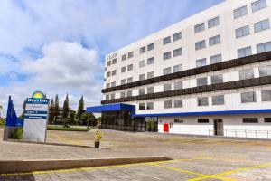 a large white building with a sign in front of it at Days Inn By Wyndham Cascavel in Cascavel