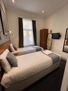 Postel nebo postele na pokoji v ubytování Apollo Hotel Kings Cross