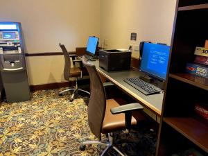 an office cubicle with two computers on a desk at Staybridge Suites Milwaukee West-Oconomowoc, an IHG Hotel in Oconomowoc