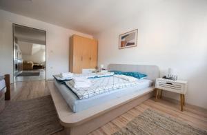 1 dormitorio con 1 cama grande y mesita de noche en Apartman Luca, en Livno