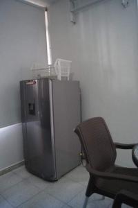 una silla junto a una nevera en una habitación en VITAL- APARTAMENTO Sector san alonso, en Bucaramanga