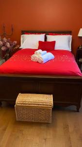 Una cama con una manta roja y dos toallas. en Gîte du Pionnier en L'islet Sur Mer