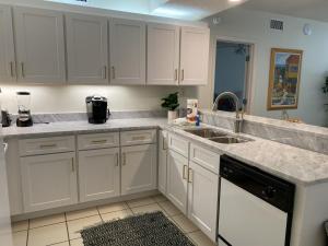 a kitchen with white cabinets and a sink at Shoalwater 604 Condo in Orange Beach