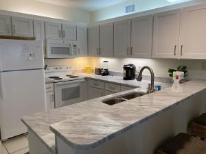 a kitchen with white appliances and a counter top at Shoalwater 604 Condo in Orange Beach