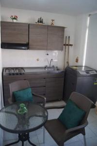 a small kitchen with a table and chairs and a sink at VITAL- APARTAMENTO Sector san alonso in Bucaramanga