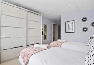 2 camas en un dormitorio con paredes blancas en Southern View By My Getaways, en Brighton & Hove