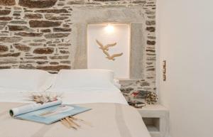 a bed with a book and a bird flying over it at Memorias Sangri Naxos in Áno Sangríon