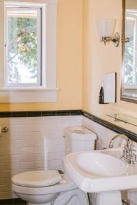 a bathroom with a toilet and a sink and a window at Salt Spring Inn in Ganges